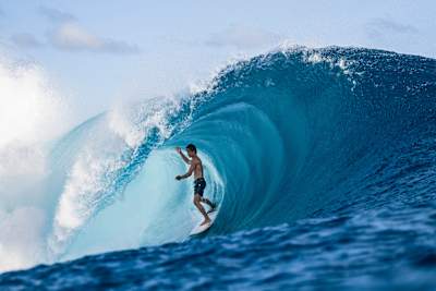 Le surfeur Eli Hanneman en train de surfer une vague à Teahupoo, Tahiti. 
