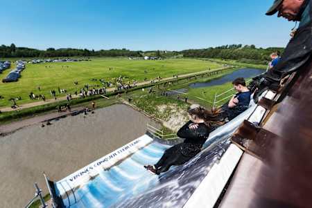 Competitors slide down a massive slide into water at the Iron Viking obstacle race.