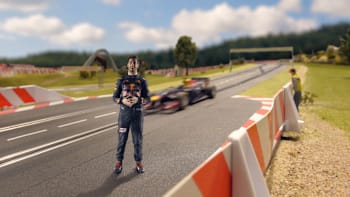 Daniel Ricciardo stands on the track on a scale model of the Red Bull Ring built with Carrera slot cars.