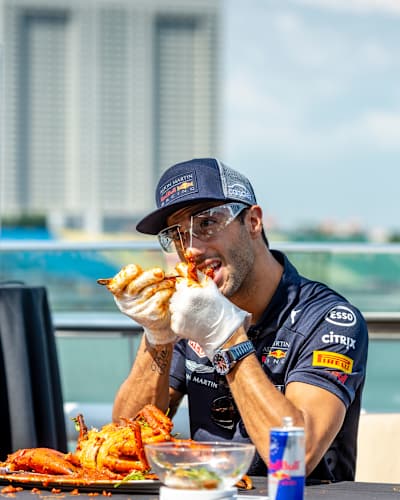 Daniel Riccardo and Max Verstappen attempt to de-shell a crab at a Red Bull event during previews ahead of the Formula One Grand Prix of Singapore at Marina Bay Street Circuit on September 13, 2018. 
