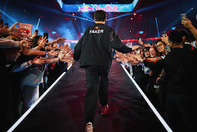 Faker, joueur emblématique de T1 et légende de League of Legends, salue les fans venus l'acclamer lors de son entrée dans une arène esport.