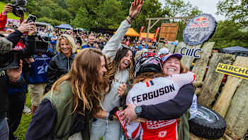 Louise Ferguson embraces her fellow female riders after completing the first full women's run at the Red Bull Hardline 2025 in Dyfi Valley, Wales.