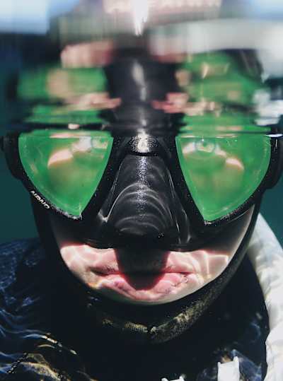 Magali Côté underneath a water line with her diving gear on
