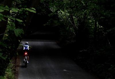 Un ciclista pedala su di una salita verso la conclusione di un tentativio di Everesting.