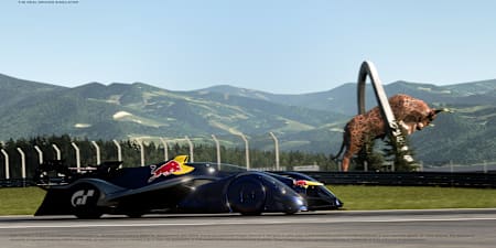 Un Red Bull X2014 pasando por el icónico toro saltarín del Red Bull Ring en el videojuego Gran Turismo 7.