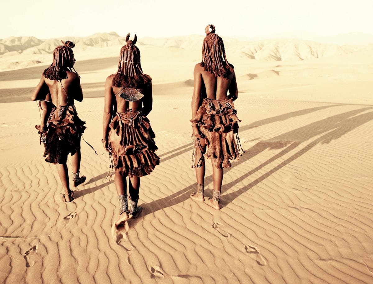 Himba people walking through the desert of the Hartmann Valley