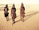 Himba people walking through the desert of the Hartmann Valley