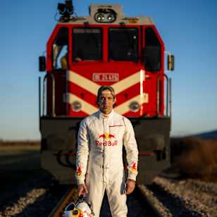 Dario Costa in Red Bull flight suit stands boldly on railway tracks during Train Landing in Afyonkarahisar, Turkey, February 2026, celebrating extreme adventure and innovation.