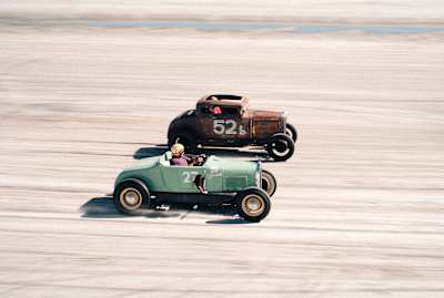 Pete Flaven in the Ford Model A Coupe against a green 1926 Ford Model T