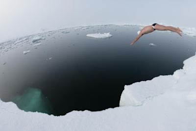 Lewis Pugh jumping into the icy cold water of the North Pole during his historic first long-distance swim at the top of the wolrd