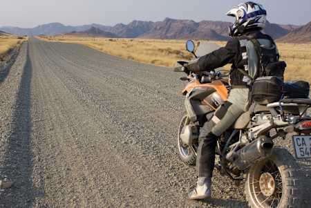 Motorradabenteurer Charlie Boorman fährt auf seiner BMW in der Savanne von Südafrika