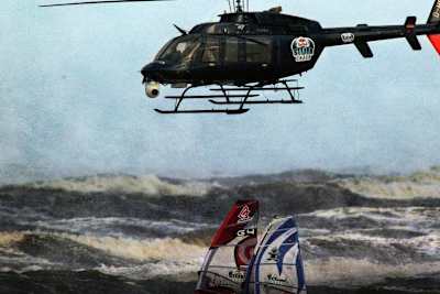 A helicopter tracks competitors during the Red Bull storm Chase windsurfing contest.
