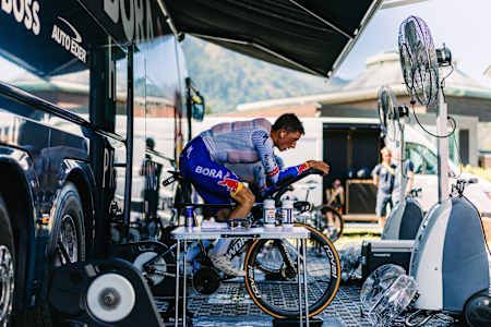 Red Bull BORA hansgrohe cyclist Florian Lipowitz warms up during the strenuous 13th stage of the Tour de France 2025 in Loudenvielle Peyragudes, showing energy and concentration in the team bus