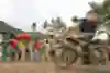 In a blur, a Spanish team mountain-bikes past a Fijian village on the third day of the grueling multisport competition.