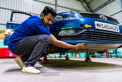 Dean Mascarenhas checks the skid plate on his rally car