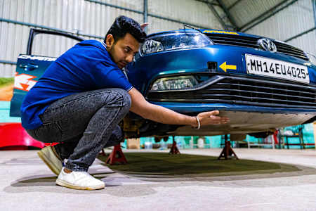 Dean Mascarenhas checks the skid plate on his rally car