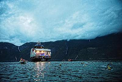 A photo of triathletes entering the icy waters of a Norwegian fjord during the Isklar Norseman Xtreme Triathlon.