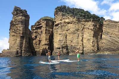 Persons on SUP boards take to the water around São Miguel in the Azores.
