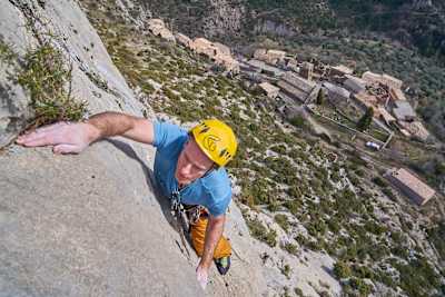 Rock climber feels smooth rock for holds in Catalunya, Spain.