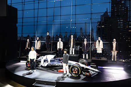 Scuderia AlphaTauri Formula One drivers Nyck De Vries and Yuki Tsunoda pose next to the 2023 car at a launch in New York City.