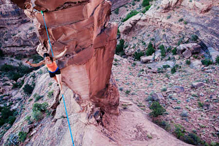 Emily Sukiennik walking a highline between a natural arch in Moab, Utah, USA. 