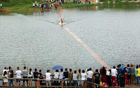 La folla guarda Shi Liliang camminare sull'acqua