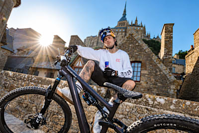 Kriss Kyle pose avec son VTT au Mont-Saint-Michel,