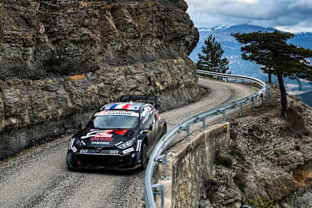 Sébastien Ogier prowadzi swoją Toyotę na zdradliwej górskiej drodze, otoczonej ośnieżonymi szczytami, podczas Rajdu Monte-Carlo, pierwszego etapu Mistrzostw Świata WRC 2025.
