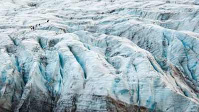 People hiking over a glacier.
