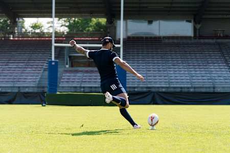 Le joueur de Rugby à 15 français Romain Ntamack frappe le ballon du pied lors d'un entraînement.