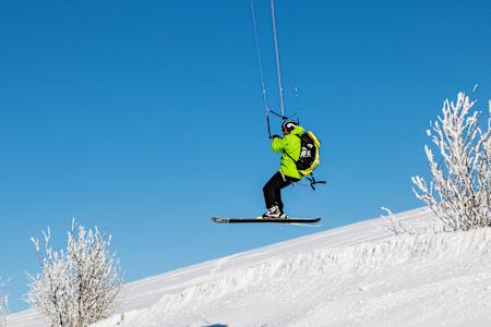 Un rider fait du snowkite dans une station de ski.