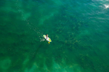 A woman stand up paddling on the Lake Geneva in Switzerland, shot from a drone camera