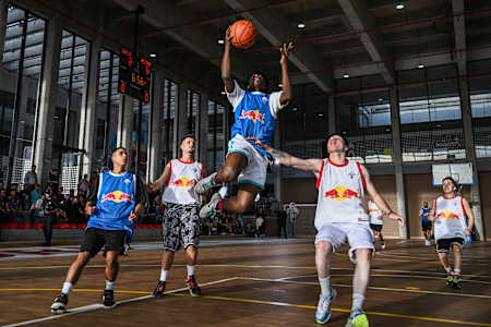 Un joueur réalise un layup lors d'un match de basketball.