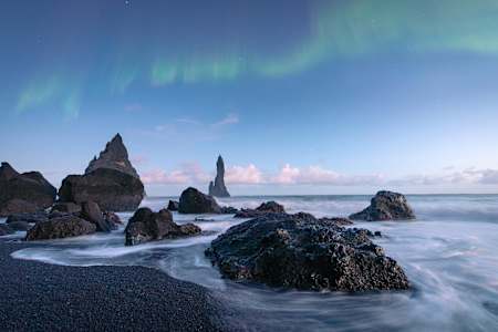 Le stack Reynisdrangar en Islande sous une aurore boréale