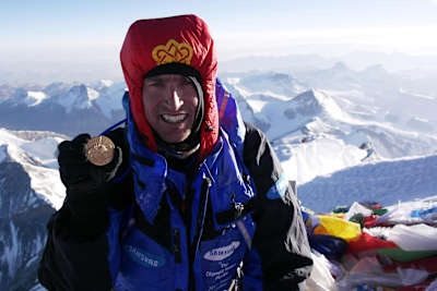 Kenton Cool posing for a portrait on the top of Everest in 2012.