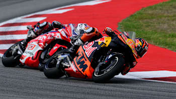 In the exhilarating 2025 Catalunya MotoGP, Maverick Viñales leans into a dramatic corner on his Red Bull KTM during a fierce race battle, embodying Red Bull’s high-octane racing spirit
