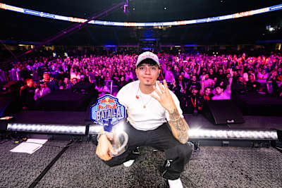 El 2 de octubre de 2025, Valles T triunfa en la Final Nacional de Red Bull Batalla en Bogotá, Colombia, sosteniendo el trofeo de campeón ante una vibrante multitud de aficionados en la arena