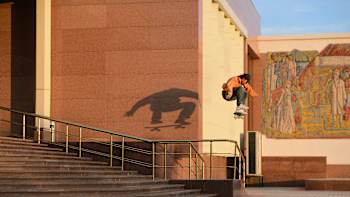 A skateboarder jumps in the air off steps.