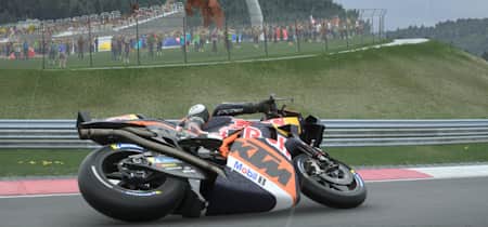 Screenshot aus MotoGP 24 zeigt die KTM von Brad Binder vor dem Eisernen Bullen am Red Bull Ring bei Regen.