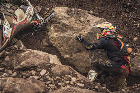 Un competidor de Erzberg intenta recuperar su moto.