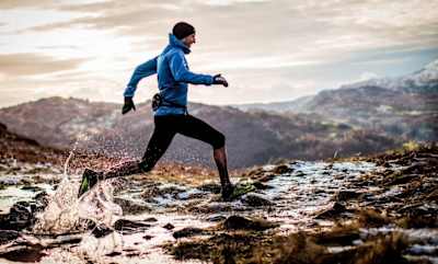 Runner splashes over marshy ground out in the mountains.