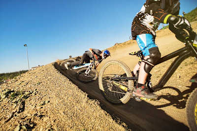MTB riders ride a flowy trail at BikePark Winterberg in Germany.