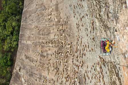 Sasha DiGiulian sleeps while suspended from a rock face.