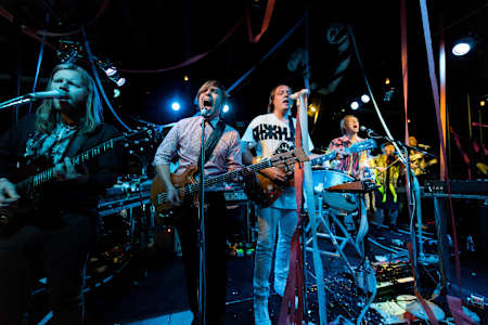 An image of Arcade Fire performing live at KROQ Studios for Red Bull Sound Space on 31 July 2014.