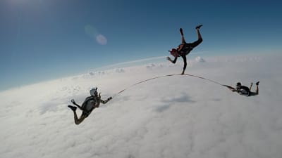 Three skydivers and one slackline.