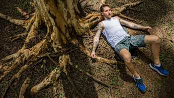 Climber Felipe Camargo lies beneath a tree.