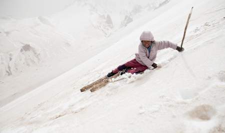 A girl skiing down a steep slope in Afghanistan.