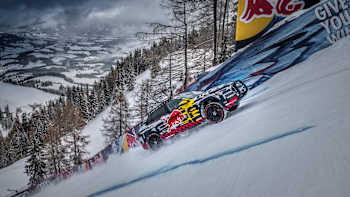 A photo of Swedish rally ace Mattias Ekström driving up Austria's Streif Mausefalle ski run.