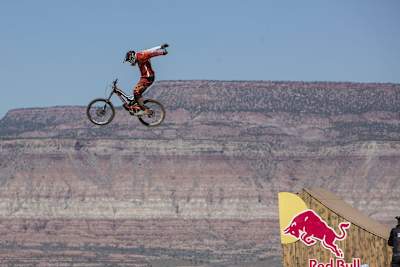 Freeride mountainbiker fietst vanaf schans lucht in zonder handen aan stuur