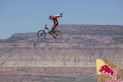 Freeride mountainbiker fietst vanaf schans lucht in zonder handen aan stuur